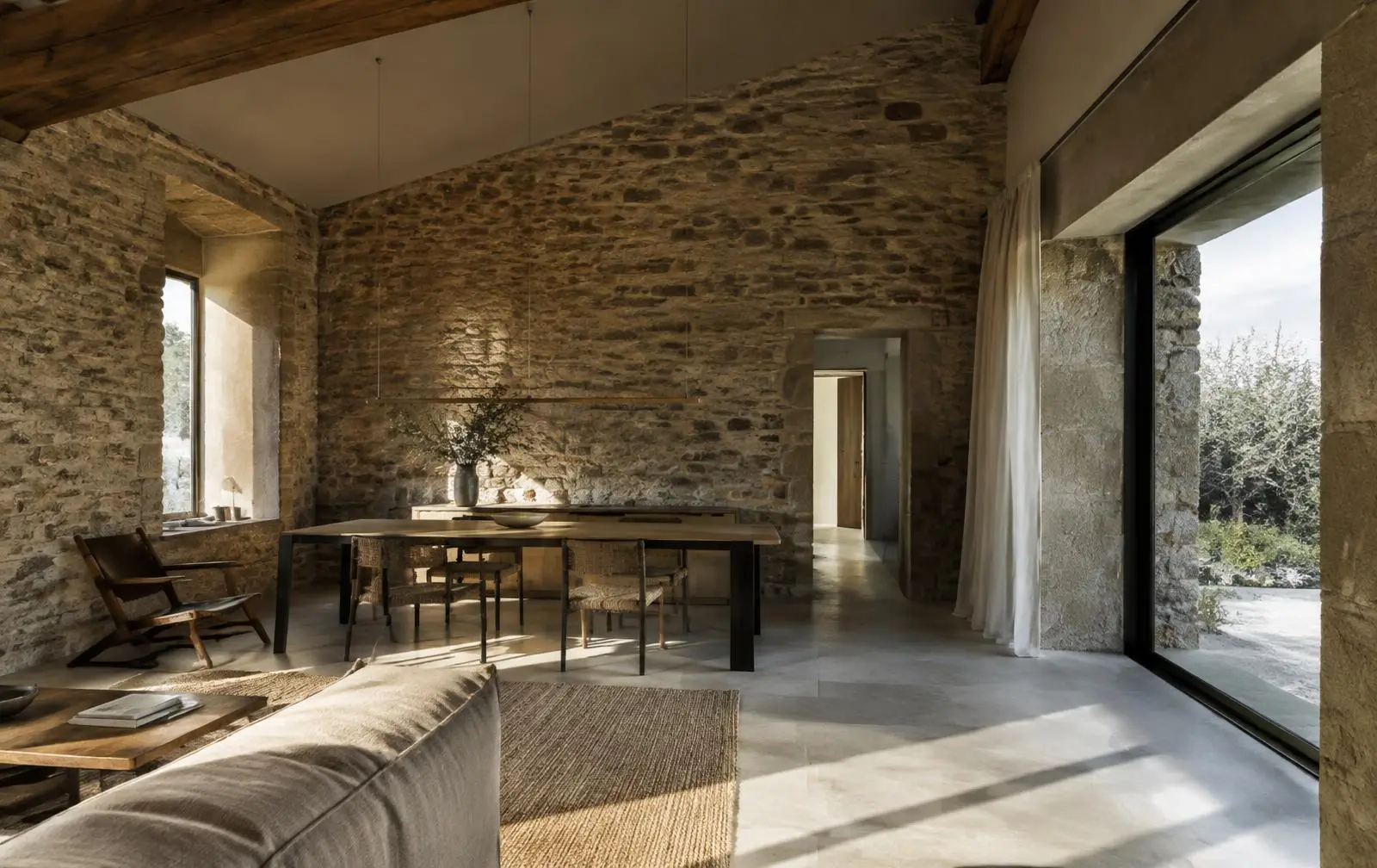 Intérieur d'une maison en pierre baigné de lumière naturelle, univers Habiter EXPERIENTIEL